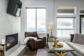 Beautiful modern living room with gas fireplace, TV, incredible views of the valley & Okanagan below. Ski right out from the home to start your day. Features private hot tub, laundry, BBQ and garage for parking or storage.