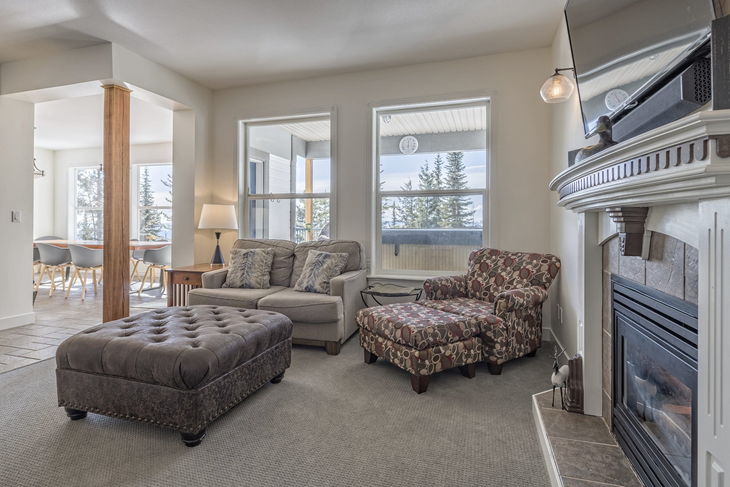Eldorado living room with incredible views of the Monashee Mountains, gas fireplace, TV, dining area and table, fully stocked kitchen. Private Hot tub, shared laundry and ski room with waxing bench.