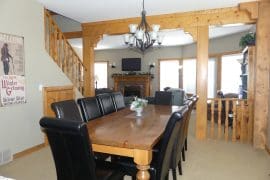 Dining Room Table and area of Chalet. Close to the village and adventure park and nestled in the trees. Private hot tub under gazebo, laundry, BBQ and space for everyone to spread out.