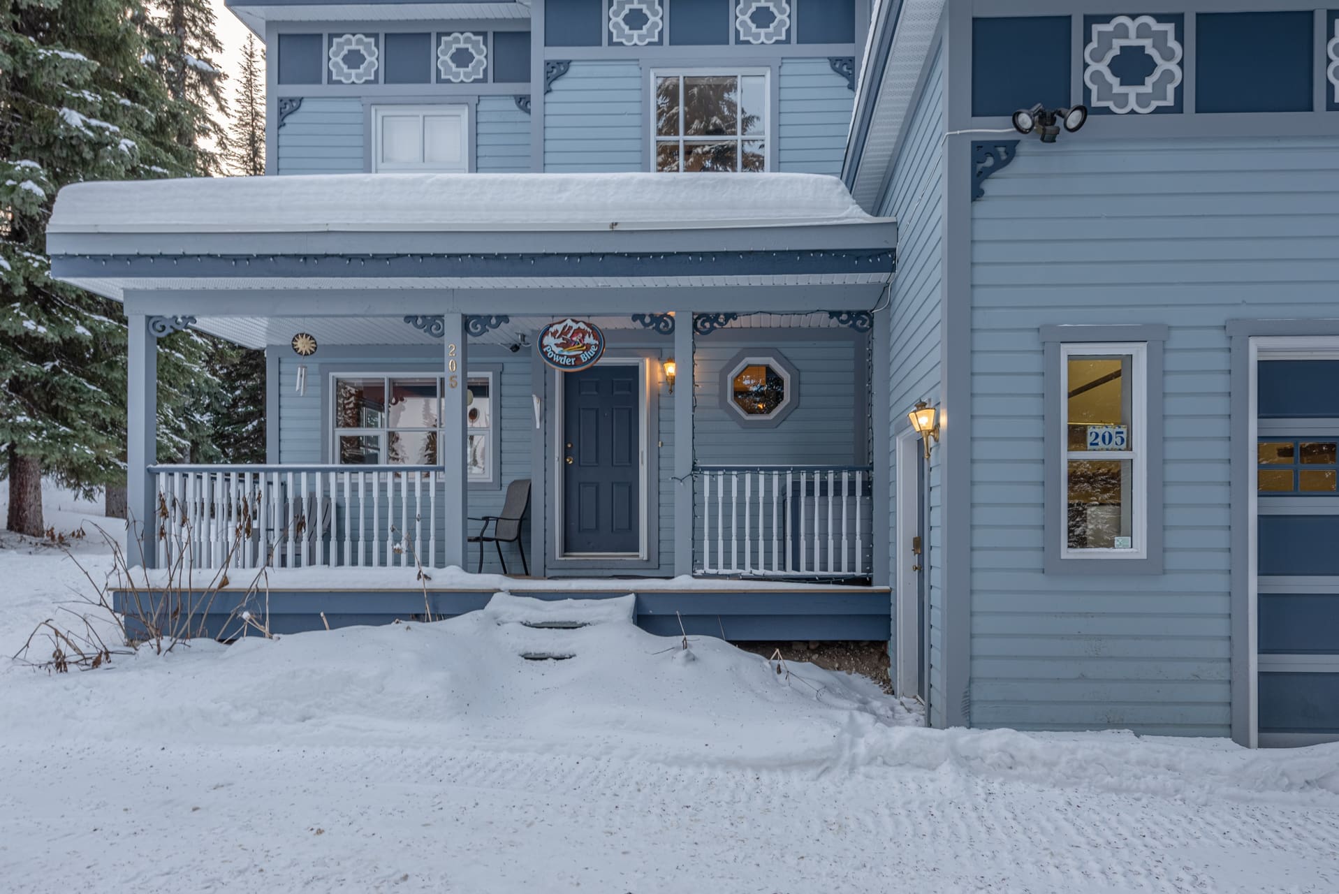 Exterior of Powder Blue House with heated garage and waxing station, private hot tub, laundry, BBQ and incredible ski in and out right from your backyard onto the skiway! Pet-friendly too.