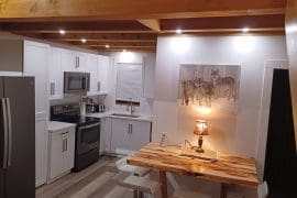 Cozy Cabin and Kitchen with high ceilings, bright lights, and loft bedroom above living space. Relax in the hot tub, sauna or enjoy the BBQ and front deck with the countryside around you.