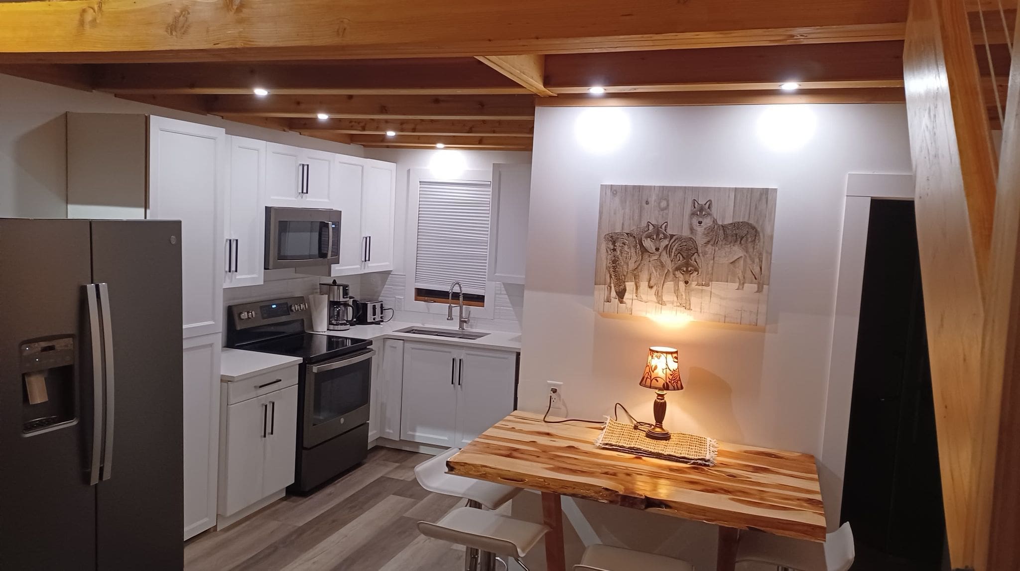 Cozy Cabin and Kitchen with high ceilings, bright lights, and loft bedroom above living space. Relax in the hot tub, sauna or enjoy the BBQ and front deck with the countryside around you.