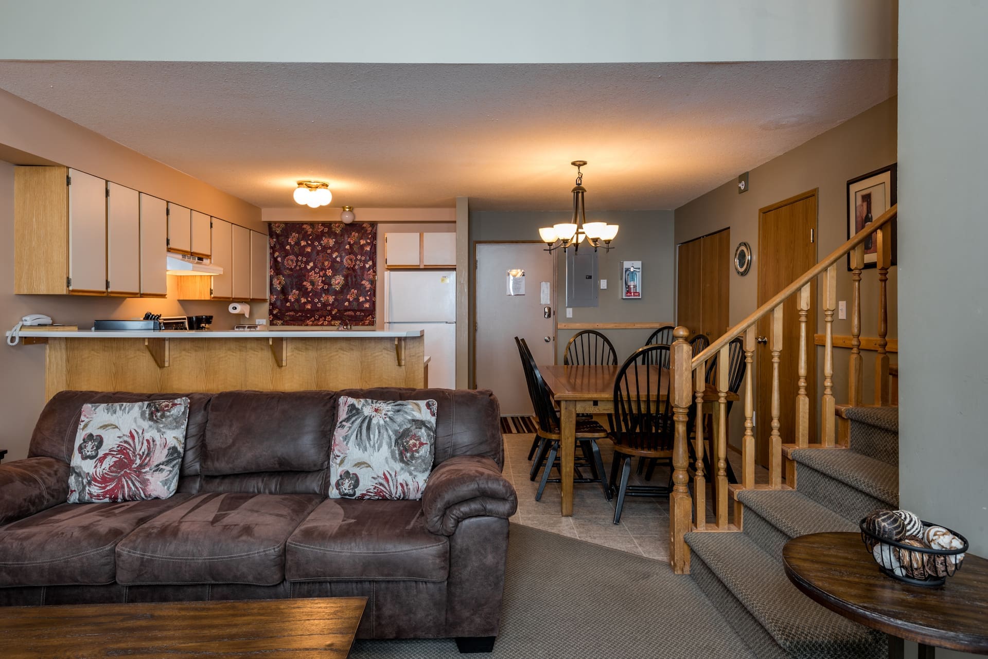 Living Room, Kitchen & Dining table area of Townhouse. Ski right from your door with beautiful views of the mountain from your private deck, hot tub and BBQ. Pet-friendly too and only steps away from the village.