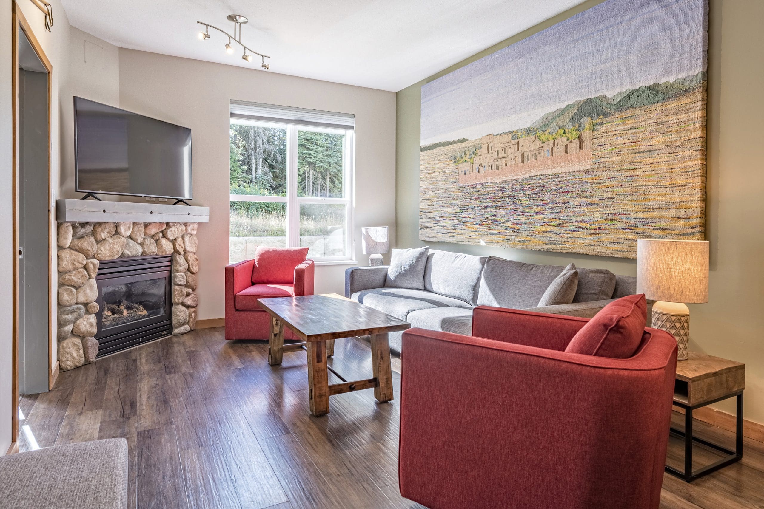 Newly renovated ground floor condo living room with gas fireplace, TV and beautiful artwork. New appliances, furnishing and hardwood floors, free parking and step right outside your door to the Silver Queen chairlift runs.