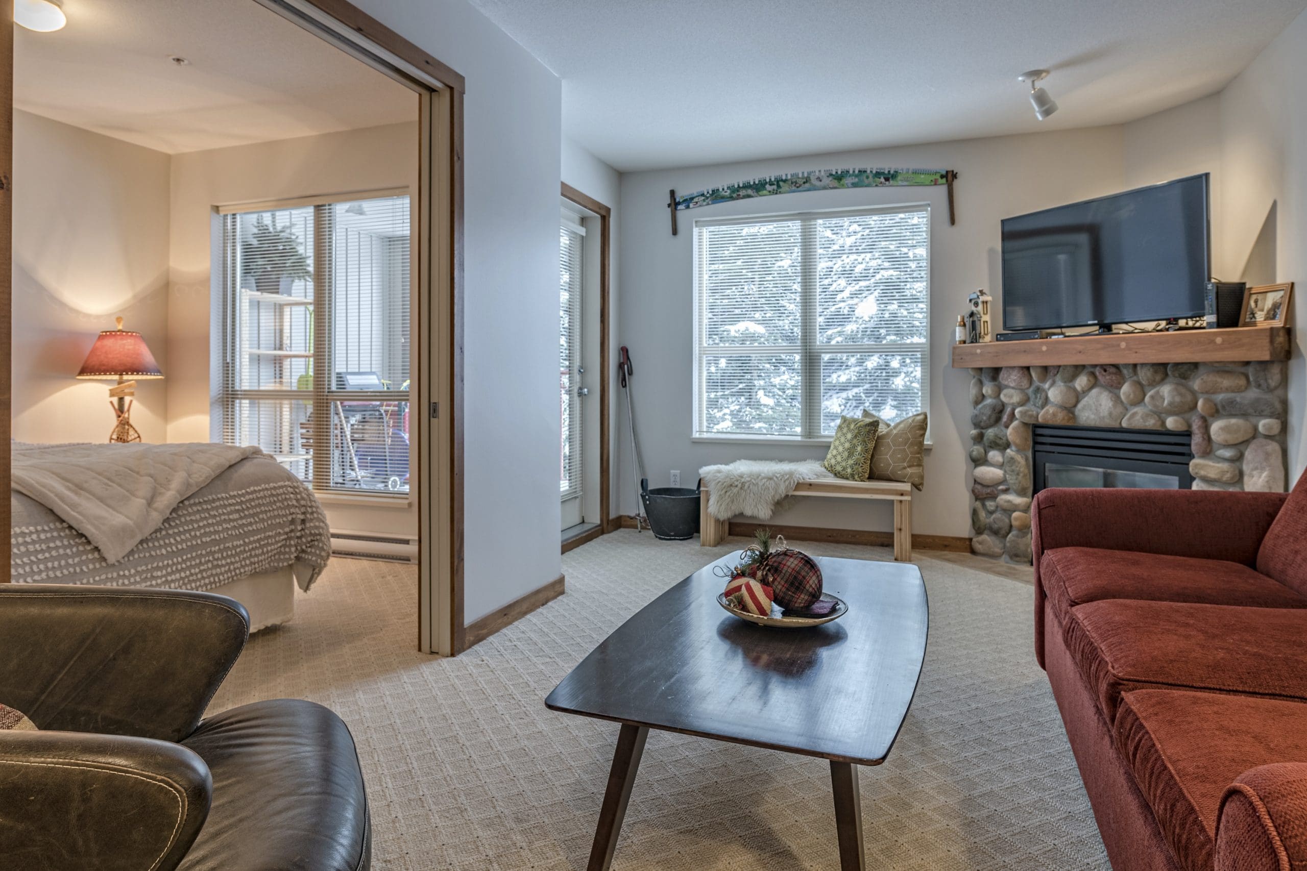 Living room of second floor condo. Ground level access from parking lot, but with a balcony with views of Silver Queen Chair. Cozy condo with gas fireplace, TV< and private alcove bunk room. Free parking and direct ski out access from building to chairlift.