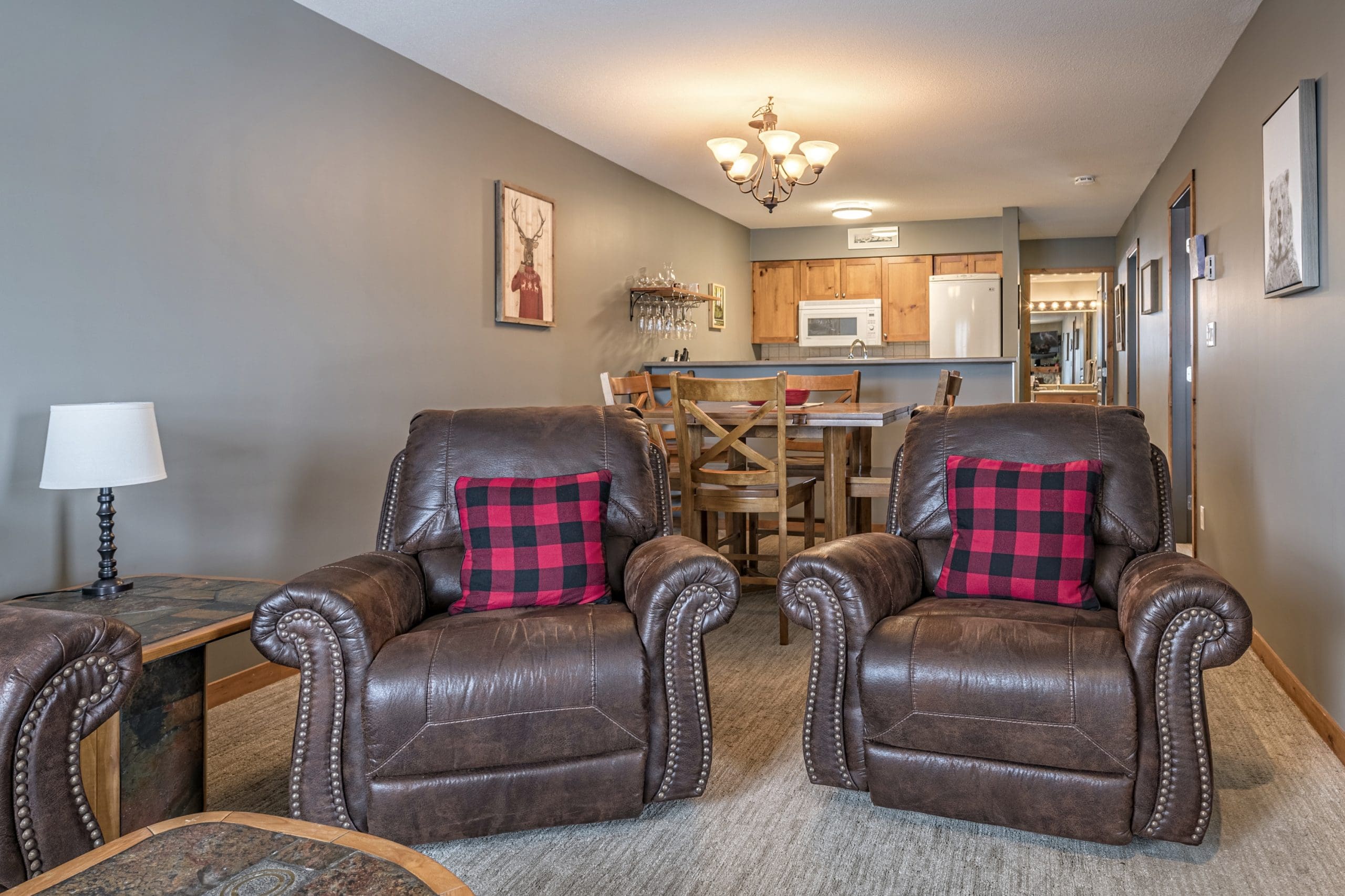 Living room with upgraded furniture and kitchen. Ground level access condo at Creekside for direct ski in and out to the Silver Queen Chair. Balcony overlooking Tube Town.