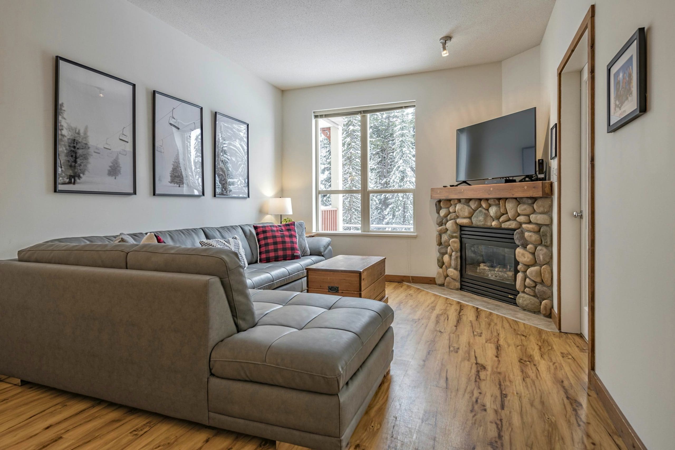 Living Room with large sectional couch, gas fireplace, TV and bright open windows with mountain views of Silver Queen Chair. Ground level condo that opens right up onto the skiway to start your day.