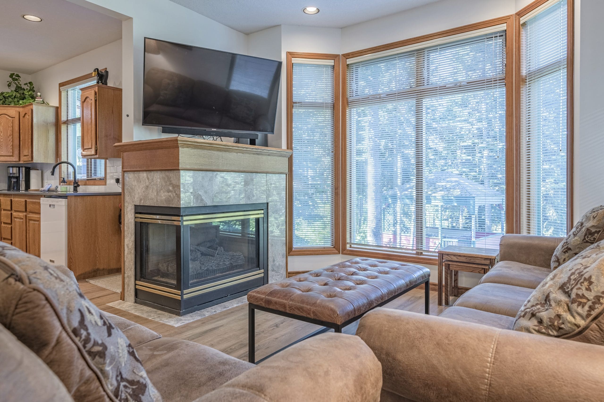 Living room with bright open windows and great views of the skating pond, gas fireplace, TV, dining area in this cozy suite. Features a garage for storage, great access to the adventure park and close to the village. It's pet-friendly too!
