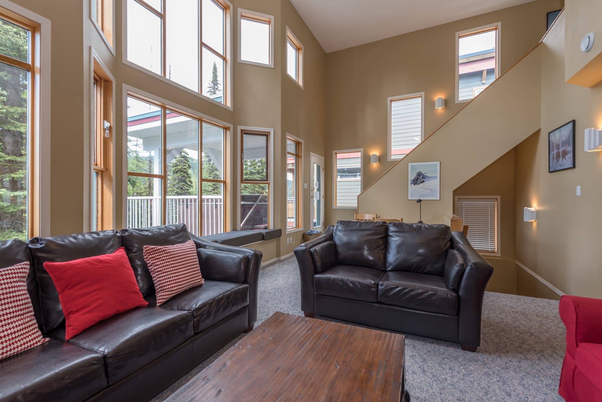 High vaulted ceilings with huge windows and incredible views of the mountains. Leather couches in living room, open concept living space for families and friends to spread out. Main level has living, dining room and kitchen seen in photo.