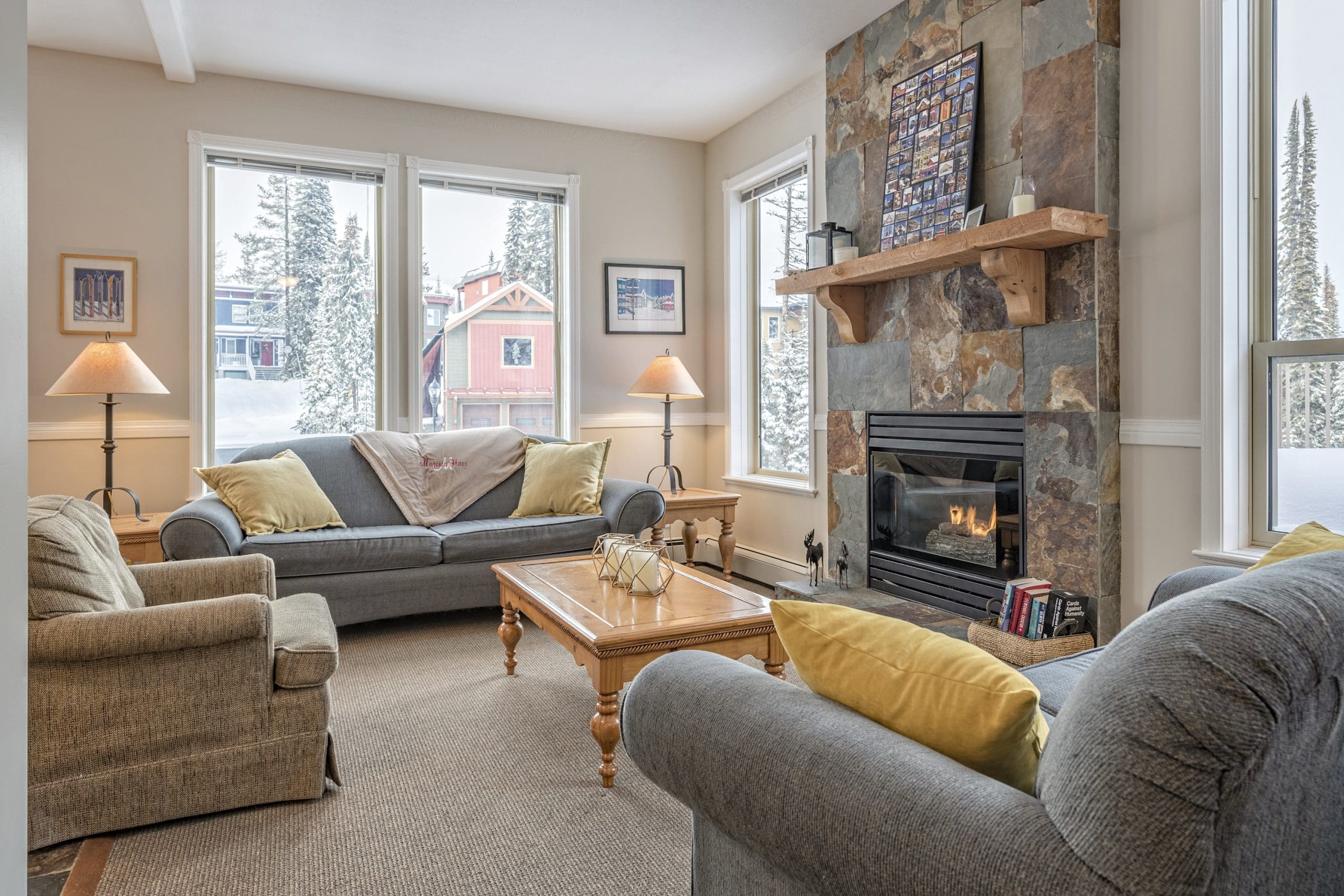 Upper Living Room with bright open windows, gas fireplace, and dining area/table. This home has two private hot tubs, laundry, and great location on the Knoll for a large family or group or friends.
