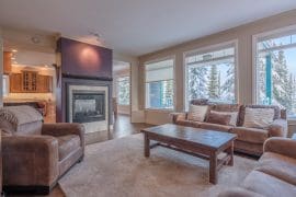 Living Room of Queenski with large double gas fireplace, bright windows with views of the Monashee mountains, private hot tub, laundry, large ground level ski room and fantastic ski-in and out right to your door.