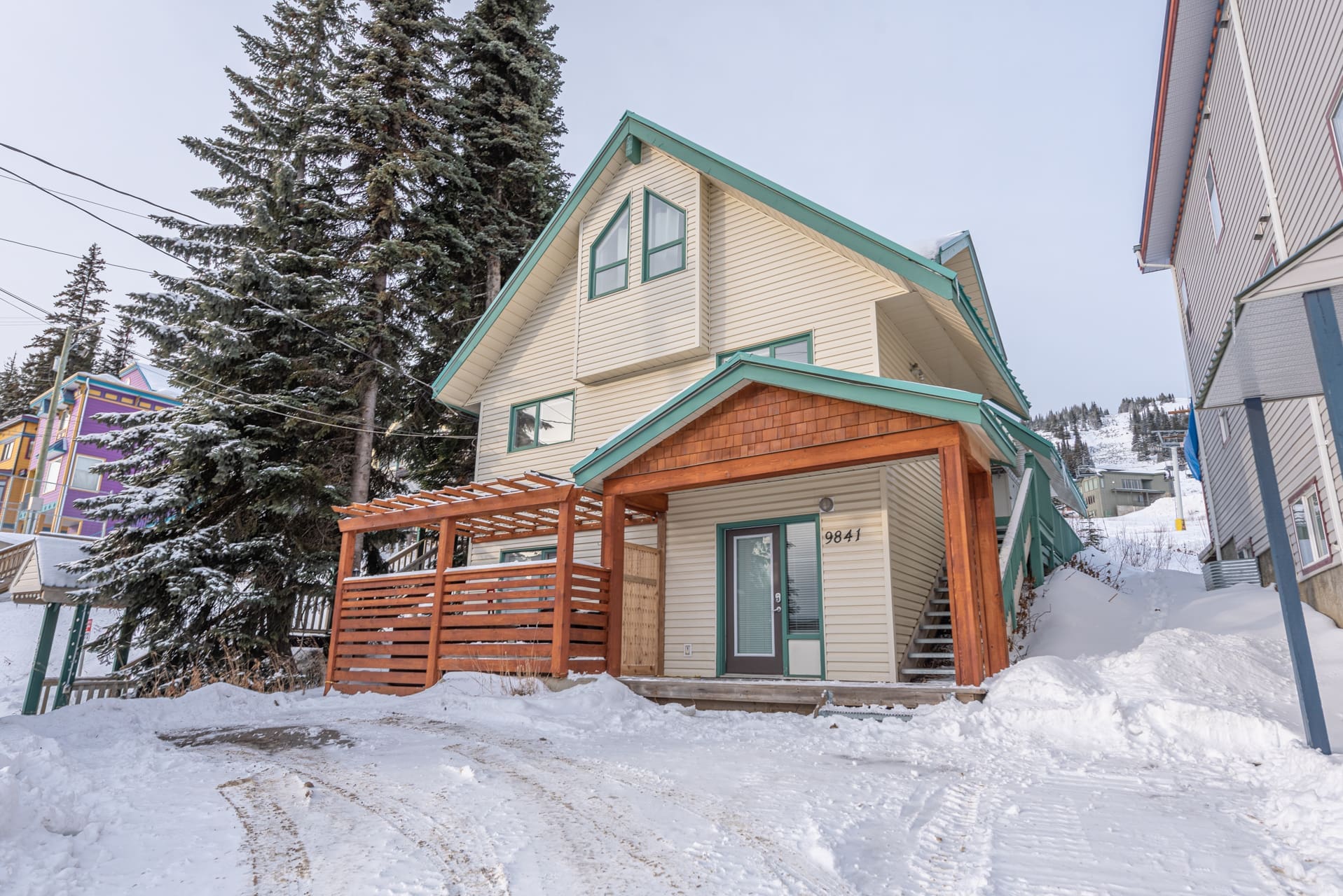 Exterior of Skimore Chalet. Backs onto the Alpine meadows chairlift, ski right from your yard onto the lift. Quick walk to the village. Private hot tub, laundry, BBQ on large deck with beautiful views of mountain and private suite on ground level with hot tub and laundry.
