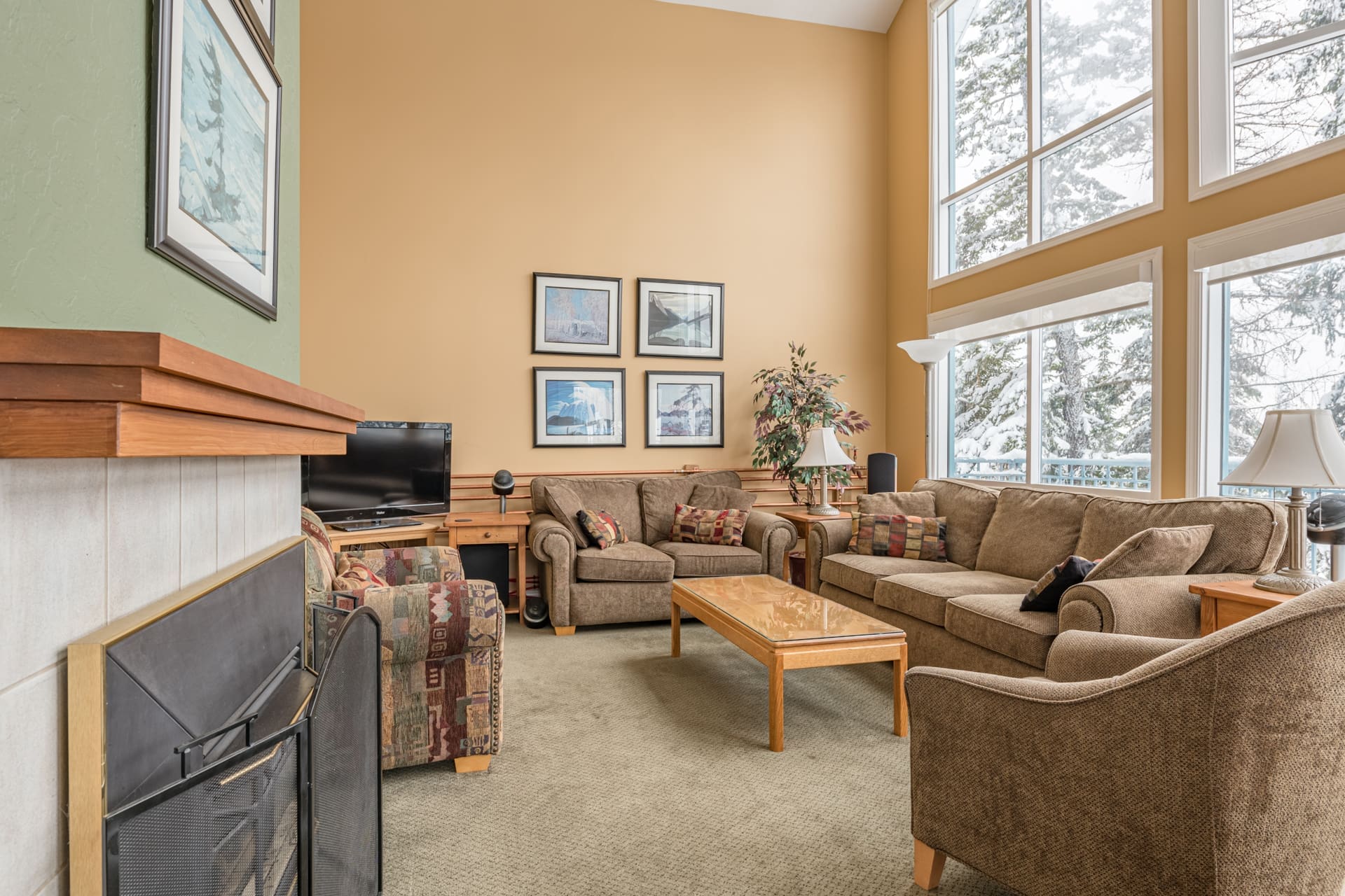 Living room of home with bright large windows and incredible views. Amazing location with skiway directly out the back door to whisk you to the village in minutes. Private hot tub, laundry, garage for storage and it's pet-friendly!