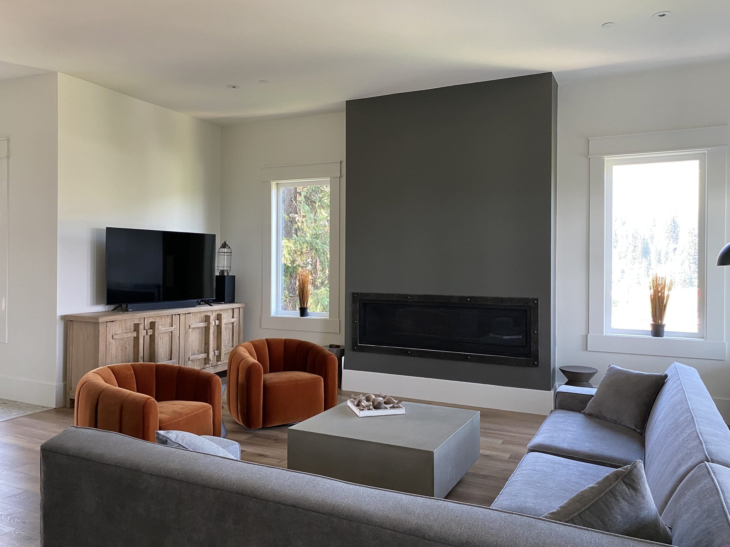 High-end modern living room with gas fireplace and bright natural light from the windows.