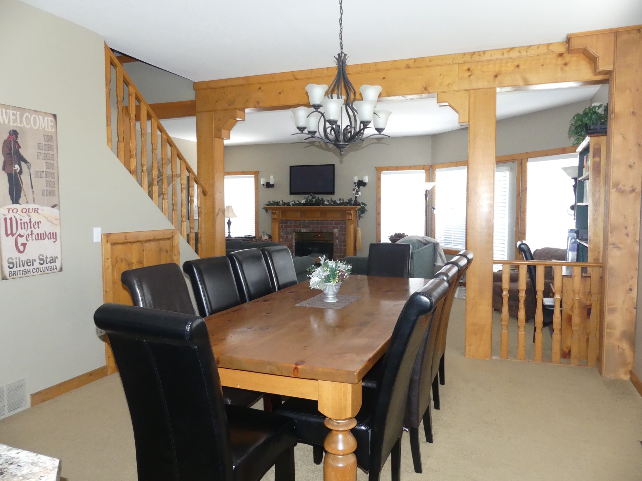 Dining Room Table and area of Chalet. Close to the village and adventure park and nestled in the trees. Private hot tub under gazebo, laundry, BBQ and space for everyone to spread out.