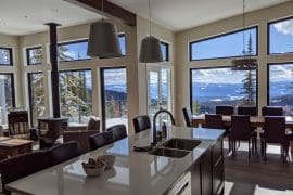 Living Room/Kitchen and Dining table with large bright windows with mountain views, fully equipped kitchen, private hot tub, laundry, lower level den/TV room.